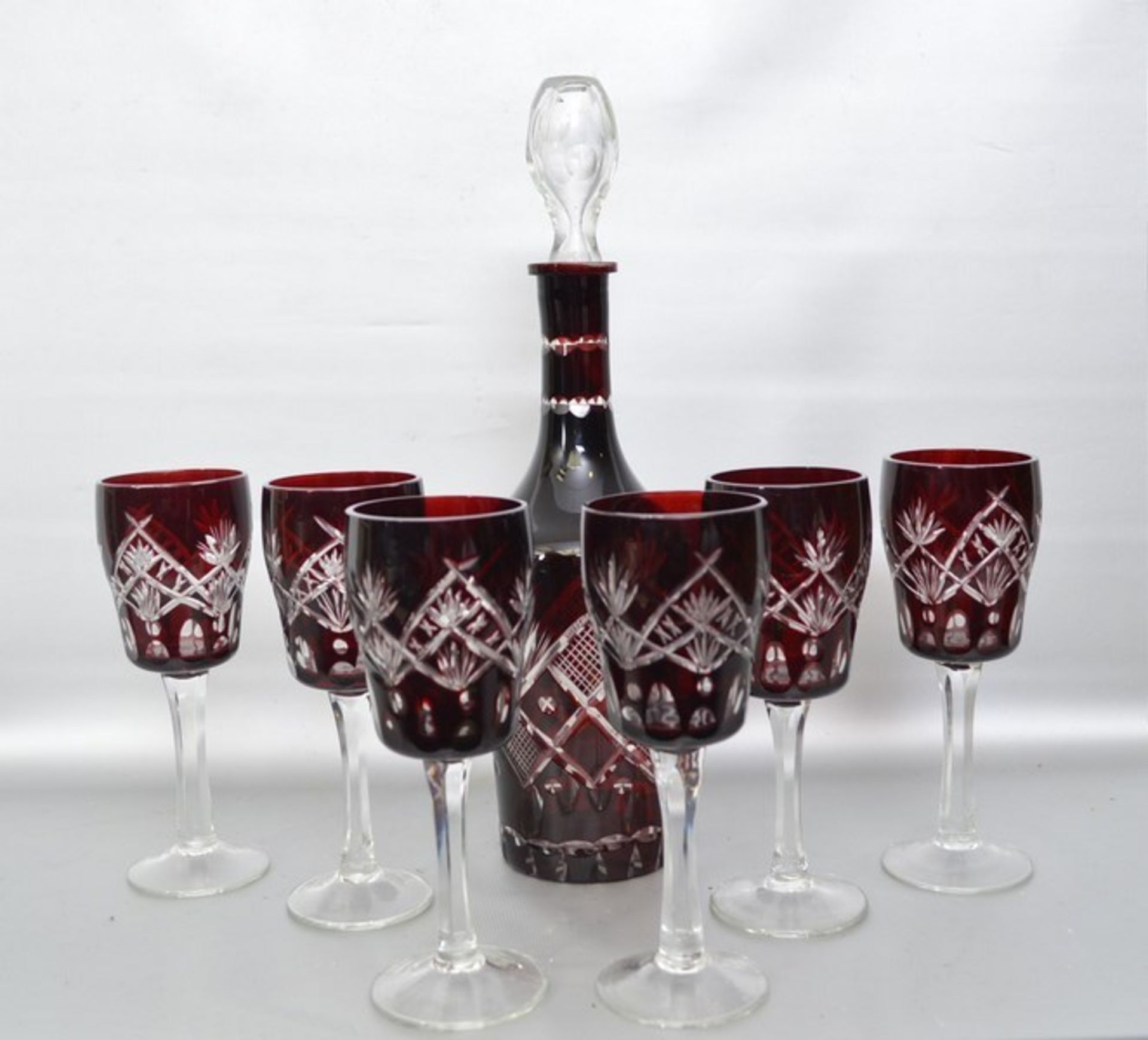 Karaffe und sechs Gläser farbl. Glas, geschliffen verziert, mit sechs Weingläsern, mit rotem