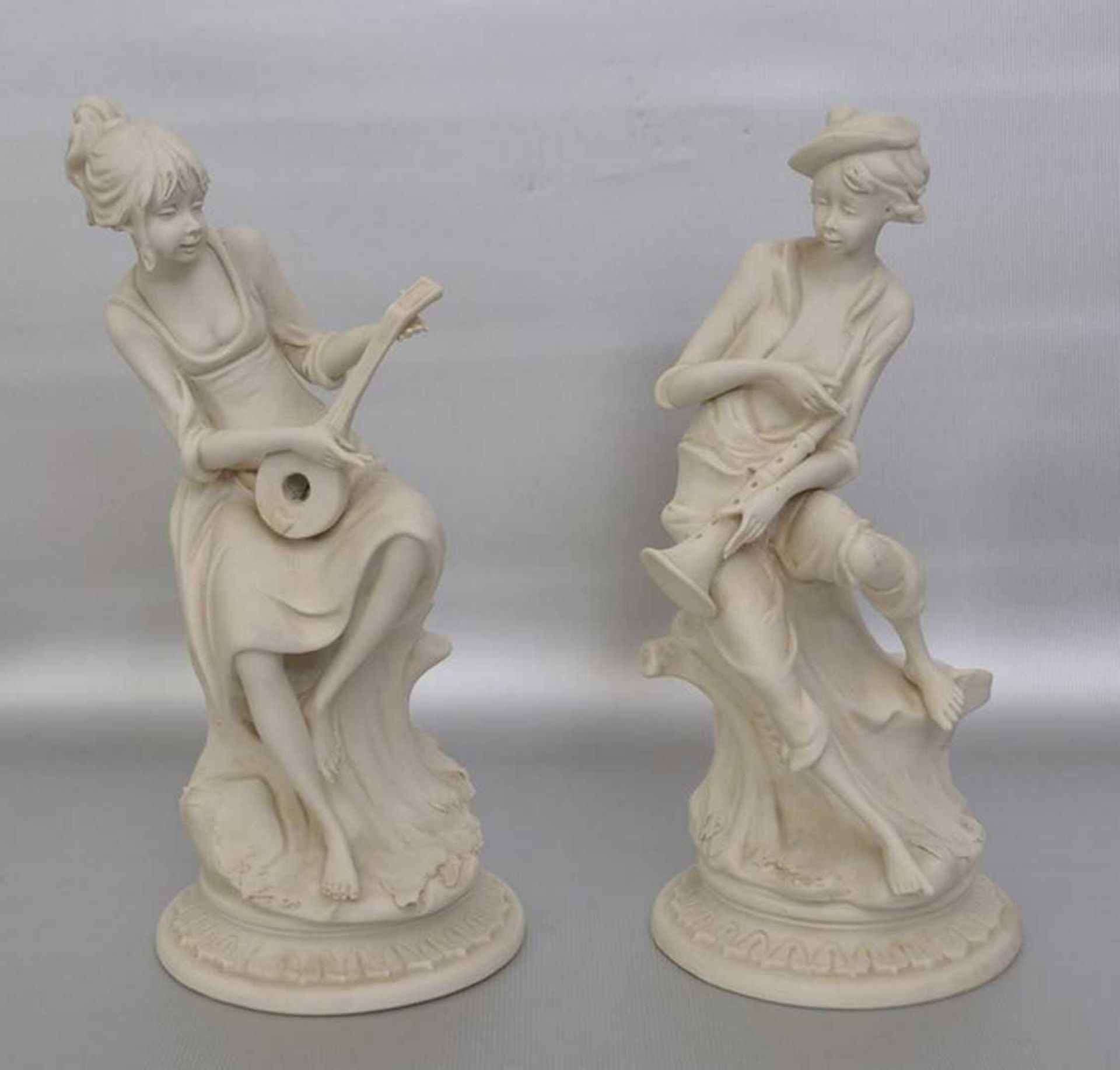 Musizierendes Figurenpaar Biskuitporzellan, auf rundem Sockel sitzend, mit Flöte bzw. Gitarre, H
