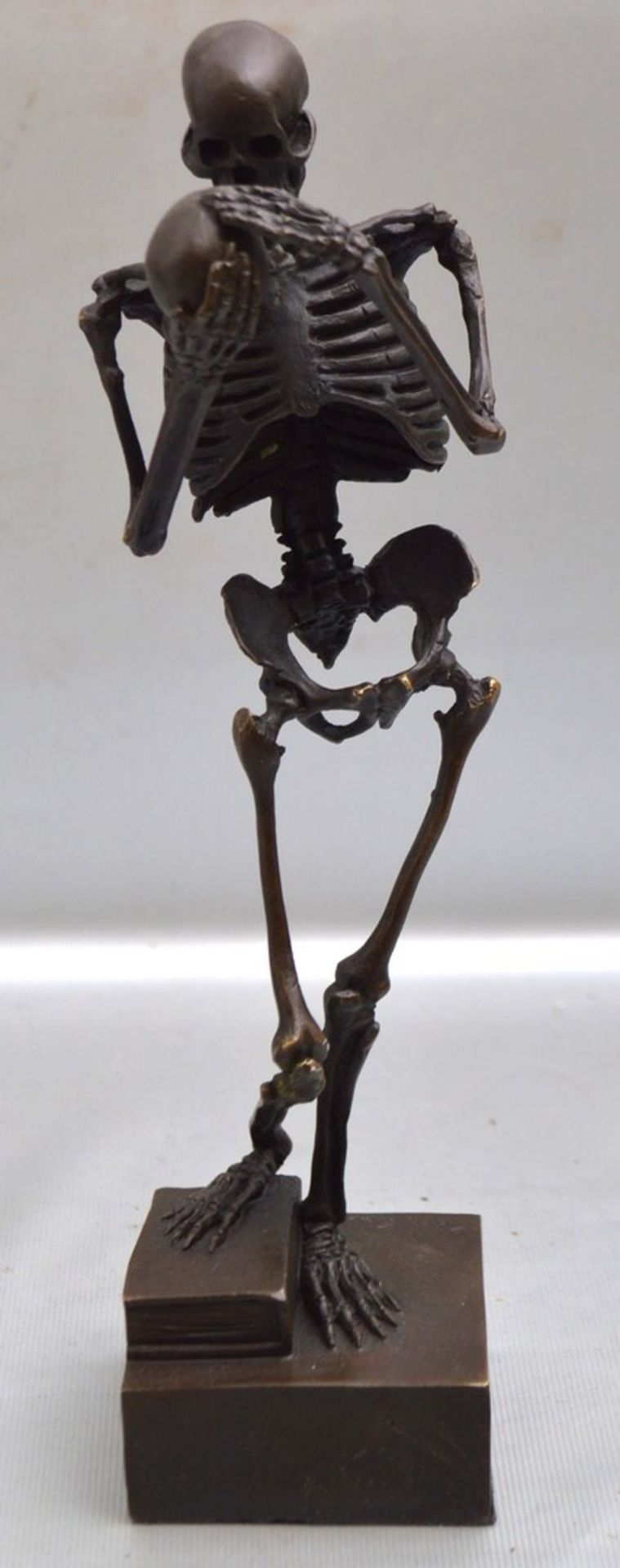 Der Tod Bronze, patiniert, quadratischer Sockel, Skelett auf Buch stehend, einen Totenschädel