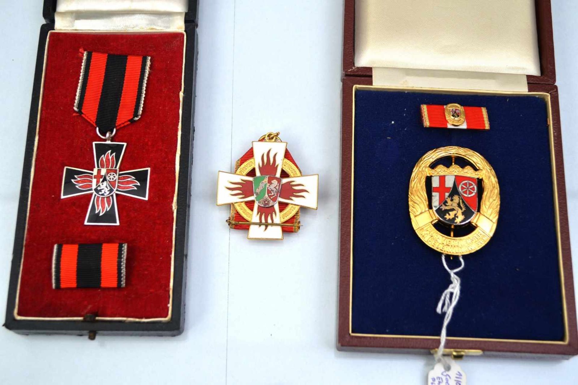 Drei Feuerwehrabzeichen verschiedene Ausführungen, zwei in originaler Schatulle, Rheinland-Pfalz