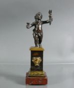 Putto (19.Jh.)Bronze, dunkel patiniert; auf Postament; frontseitig mit Kopfrelief; auf quadr.