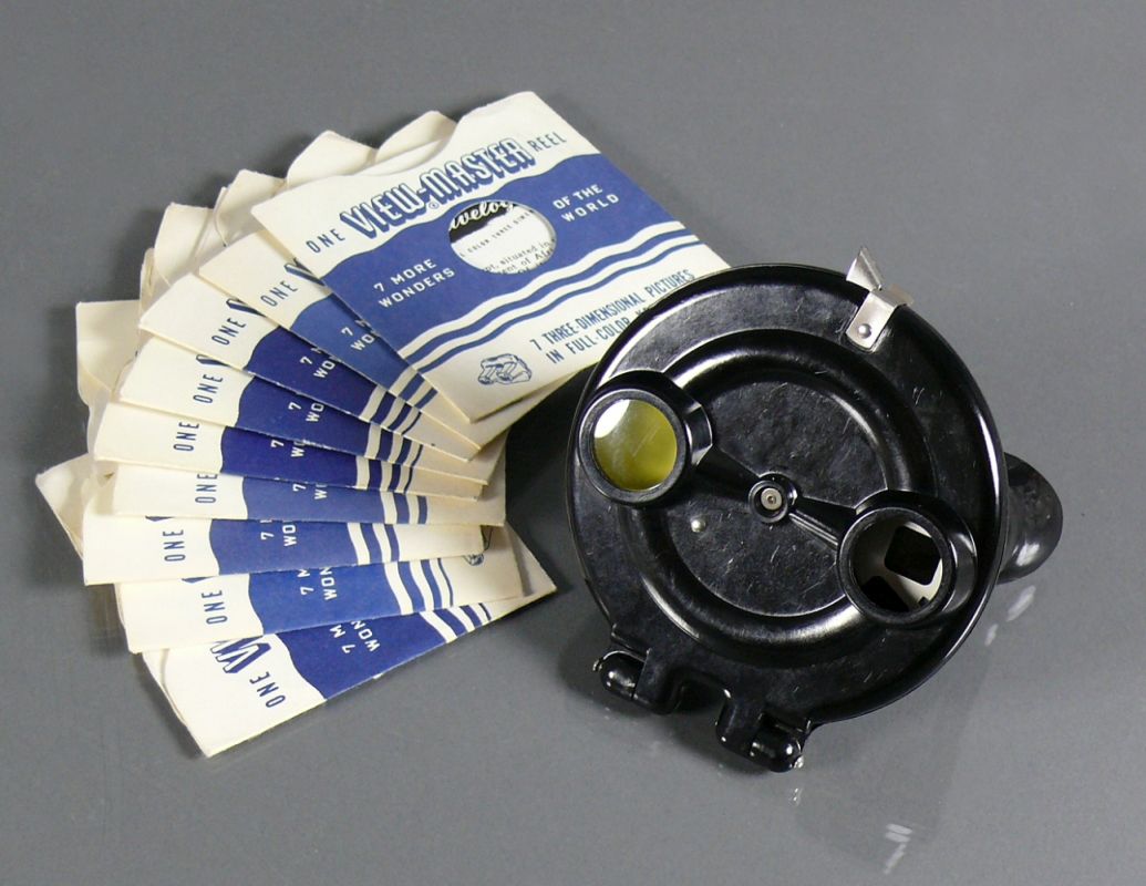 View-Master (Mitte 20.Jh.)schwarzes Bakelit-Gehäuse; mit 7 wechselbaren Scheiben (jeweils mit 14