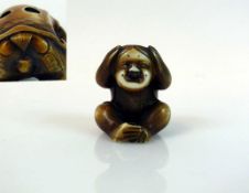 Netsuke "Affe mit Kindmaske"; tlw. dunkel gefärbt; signiert; H: 3,5 cm;