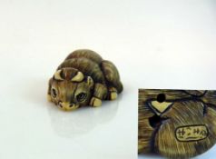 Netsuke "Liegendes Huftier mit Hörner"; signiert; tlw. schwarz gefärbt; H: 2 cm; L: 5,5 cm