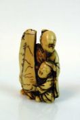 Netsuke "Sitzender Mann mit Kind" ein Schild haltend; H: 4,5 cm