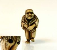 Netsuke "Stehender Mann mit Blätterumhang auf Rücken"; signiert; H: 5 cm