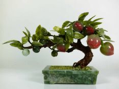 Bonsai-Baum in grünem Steinsockel; Baumstamm mit verschiedenfarbenen Früchten in Stein und Jade-