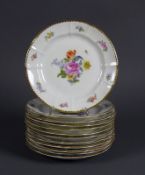 12 Teller NYMPHENBURG (1.H.20.Jh.) farbiger Blütendekor mit gewelltem Goldrand; D: je 16 cm; 2x am