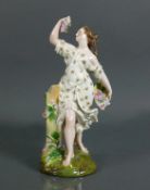 Porzellanfigur (um 1900) "Blumenverkäuferin"; Junge Frau mit Blütenschale in der linken Hand, mit