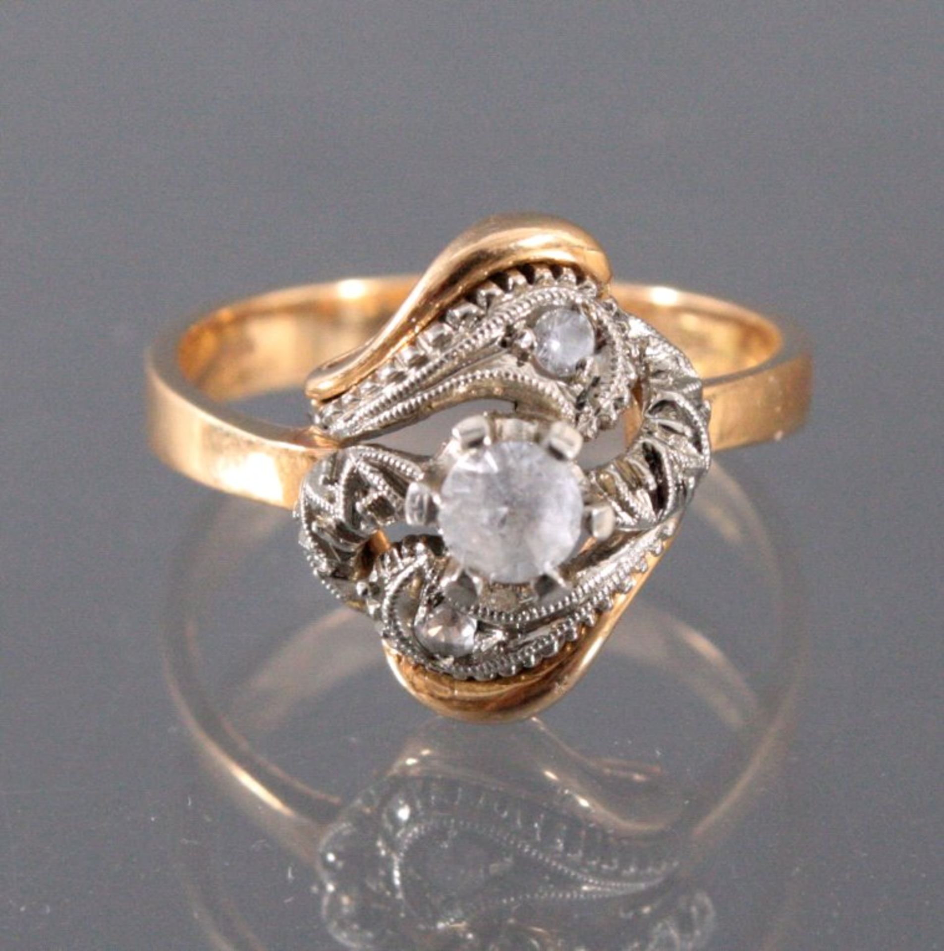 Diamantring, 18 kt Gelb und WeißgoldMittig besetzt mit einem Diamanten von ca. 0,2 kt, danebenmit