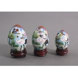 3 Cloisonne Eier, China 20. Jh.In 3 unterschiedlichen Größen von Höhe 5, 6 und 7 cm, mitHolzständer,