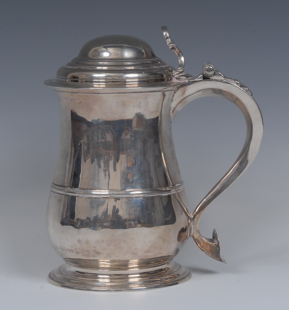 A George II silver baluster tankard, hinged domed cover with C-scroll thumbpiece,