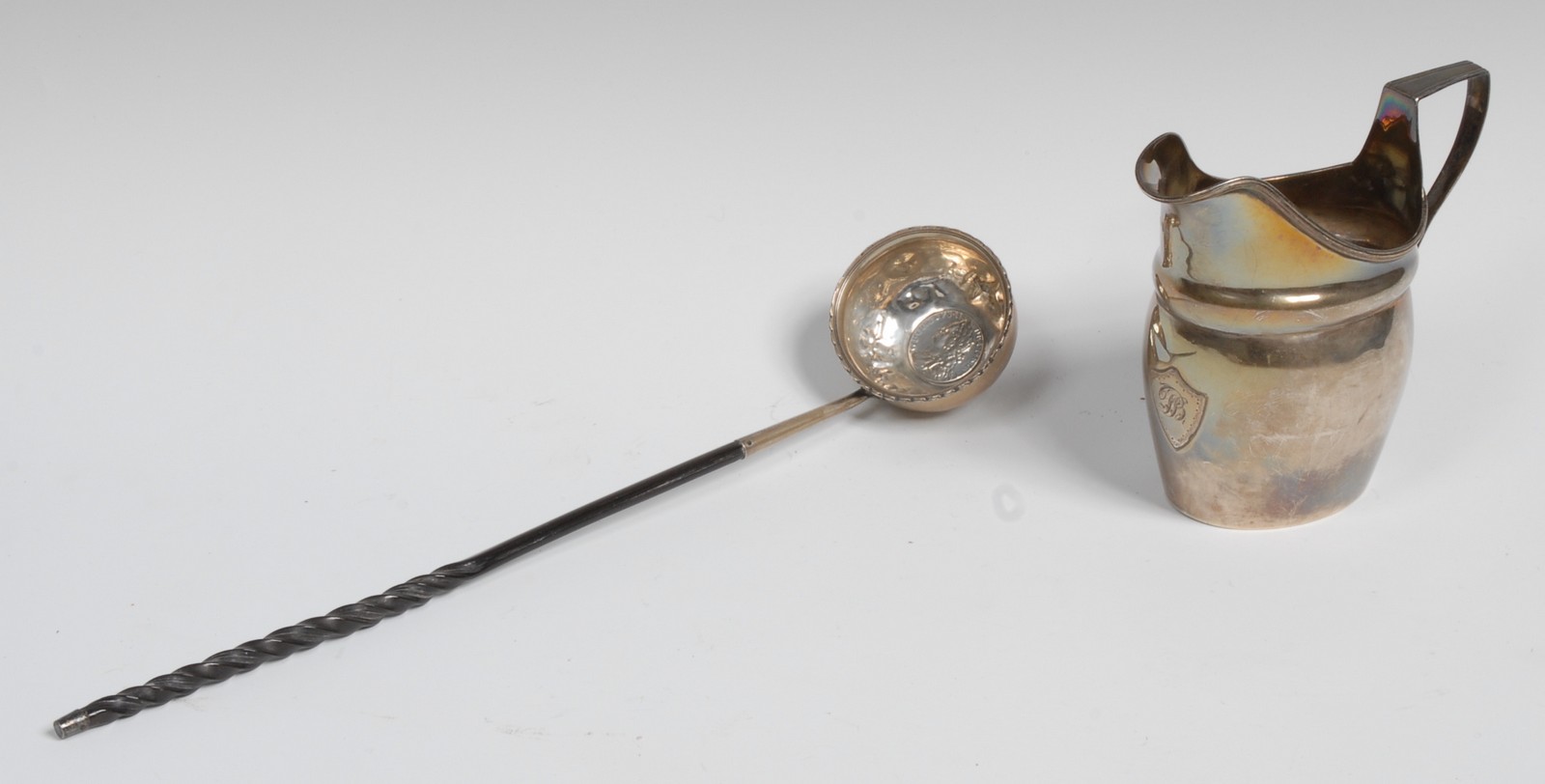 A George III silver helmet shaped cream jug, reeded borders, applied shield shaped cartouche,