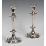A pair of silver plated candlesticks, urnular nozzles, tapering cylindrical columns,