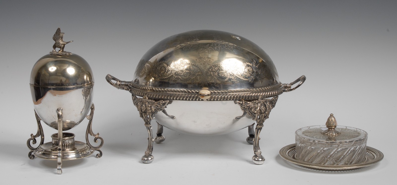 A 19th century breakfast dish, with retractable domed cover, engraved with scrolling foliage,