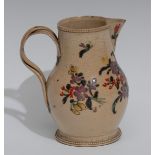 An early 19th century creamware jug, decorated in polychrome with stylised flowers and foliage,