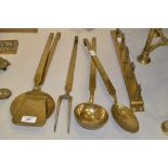 A wall hanging set of brass kitchen utensils