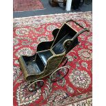 A Victorian wicker four wheel push chair, black and yellow woven body, metal sprung coil suspension,