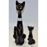 A 1970's stylised black  cat, with elongated neck, silvered eyes and bow, picked out in red,