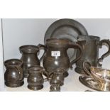 A 19th century pewter plate;  three others smaller;  a spouted mug;