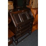 An eary 20th Century oak fall front bureau with three cockbeaded drawers