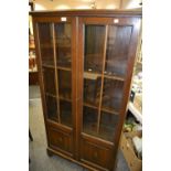 A 20th Century oak side cabinet, half glazed doors with shelves, bracket feet,