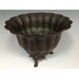 A Chinese bronze lotus dish, three scroll and pad feet, 16cm wide,