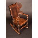 An 18th century child's wingback rocking chair, panelled back, shaped wing panels, turned legs, c.