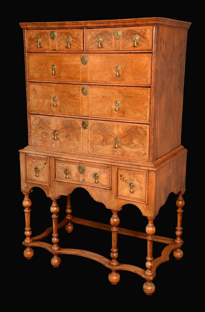 An early 18th century walnut chest on stand, feathered crossbanding,