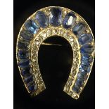 A diamond and sapphire horse shoe brooch,