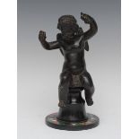 Continental School, 19th century, a dark patinated bronze, of a cherub, seated holding grapes,