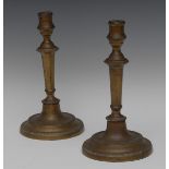 A pair of 18th century brass table candlesticks, of seamed construction, tapered stems,