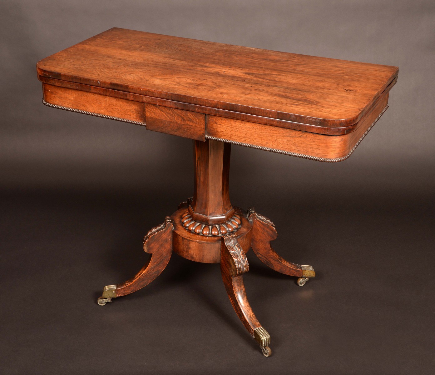 A William IV mahogany tea table, the folding rounded rectangular top with deep frieze,