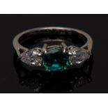 An emerald and diamond trilogy ring, central cushion cut emerald, approx 0.