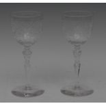 A pair of wine glasses, the bucket shaped bowls, intaglio cut with flowerheads and scrolls,