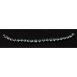 A vibrant blue zircon bracelet, composed of twenty one irregular oval stones,