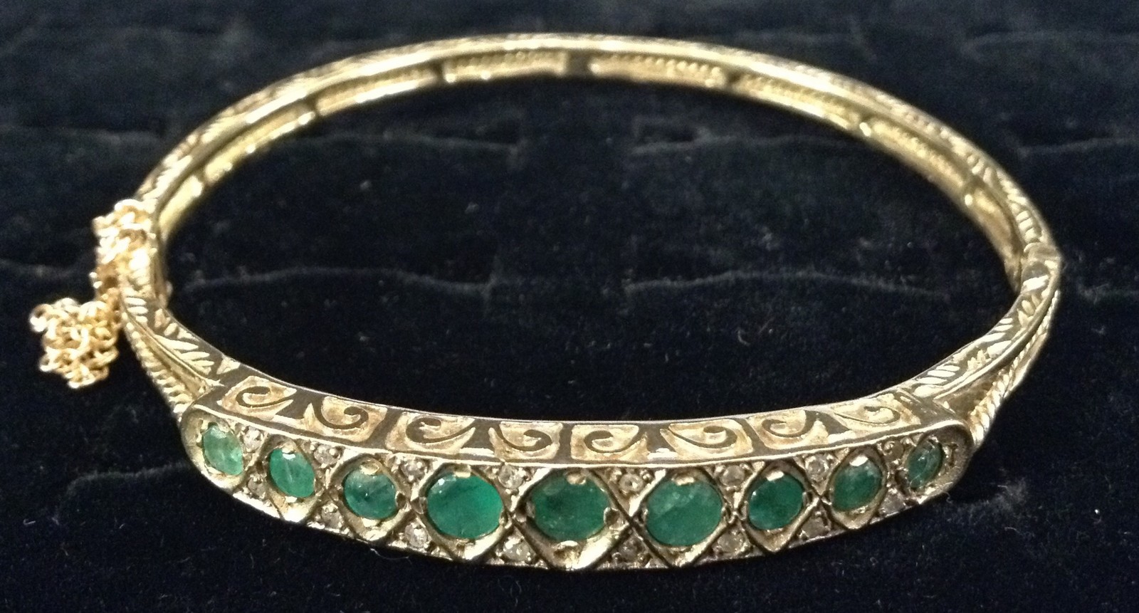 An Edwardian emerald and diamond hinge bangle, central row of nine graduated emeralds,