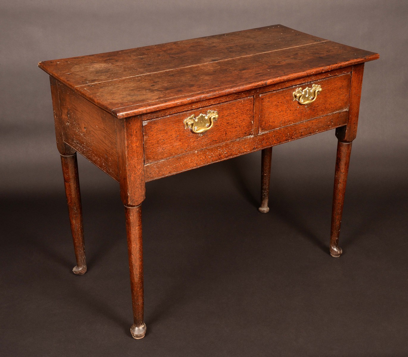 An 18th century oak side table, oversailing rectangular top, two drawers frieze,