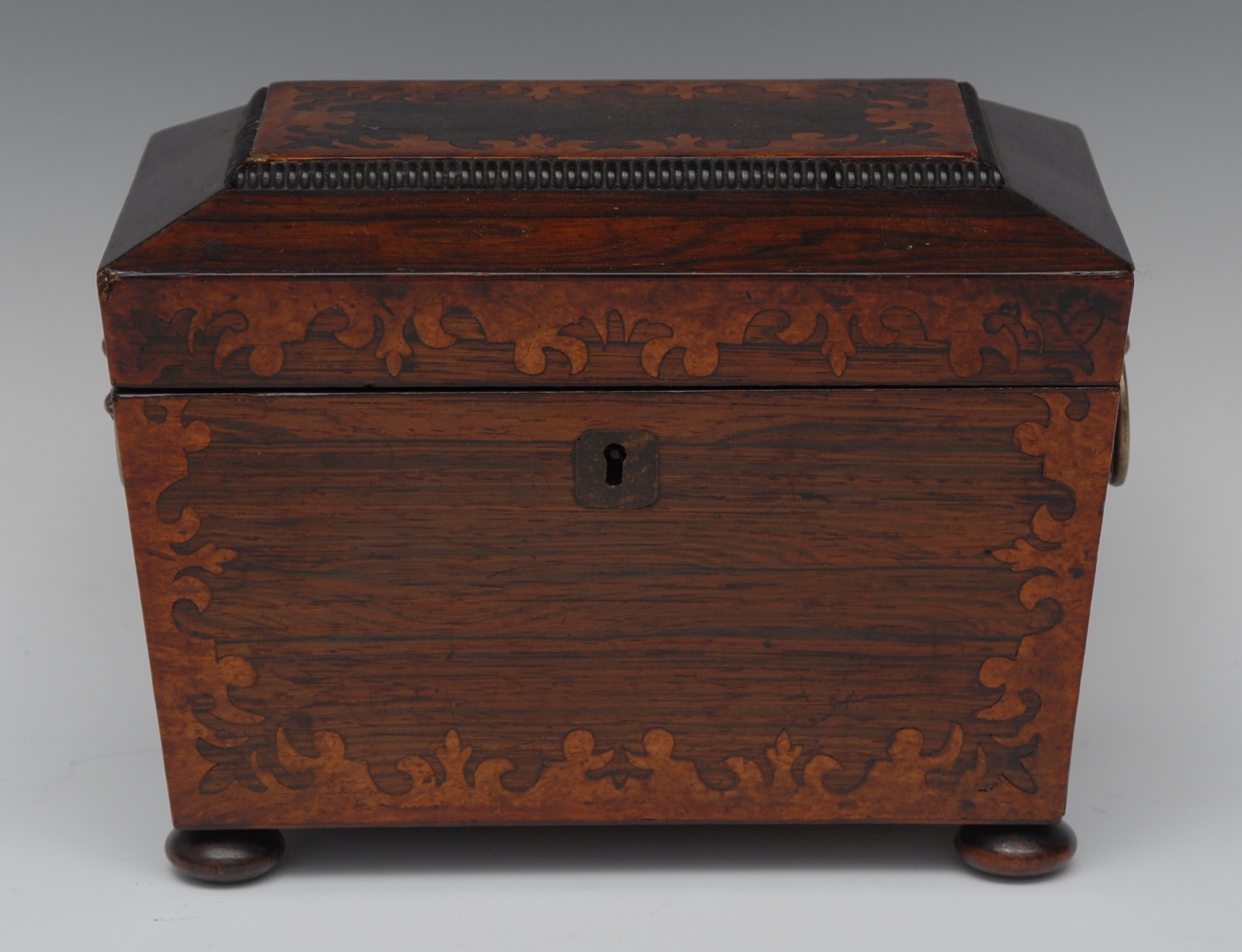 A William IV rosewood and marquetry sarcophagus tea caddy, inlaid with borders of stiff leaves,