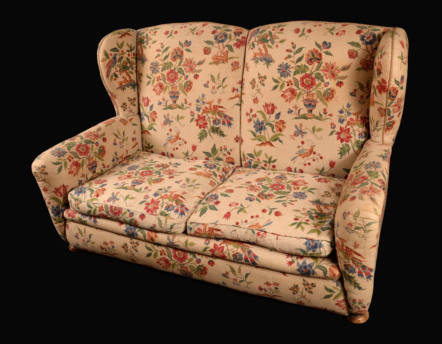 A Victorian wingback sofa, stuffed-over upholstery, squab cushions, bun feet, wooden castors,