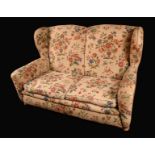 A Victorian wingback sofa, stuffed-over upholstery, squab cushions, bun feet, wooden castors,