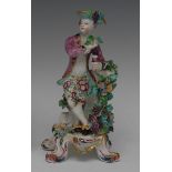 A Bow figure, Allegorical of Autumn, modelled with a with a boy holding a bunch of grapes,