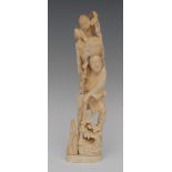 A Japanese ivory okimono, carved as an elder with a staff, a young boy in a basket above, 23cm high,