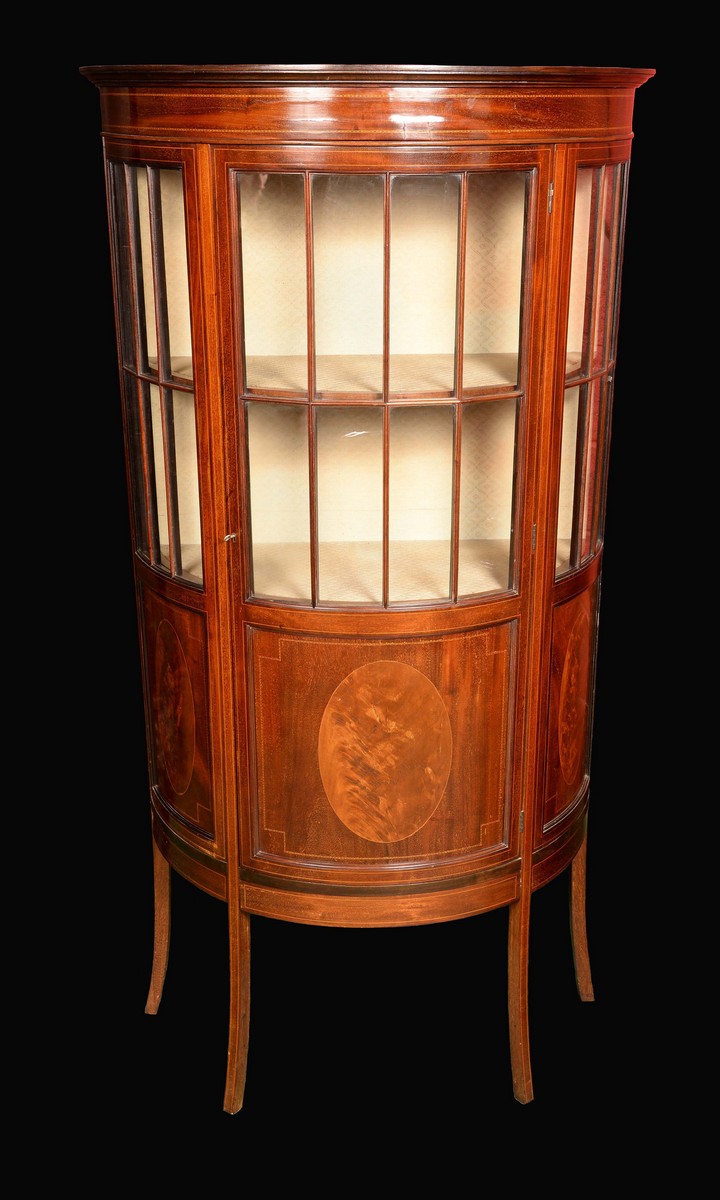 An Edwardian mahogany demi-lune display cabinet, moulded cornice above a three-quarter glazed door,