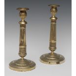 A pair of French Empire brass table candlesticks, of seamed construction, detachable nozzles,
