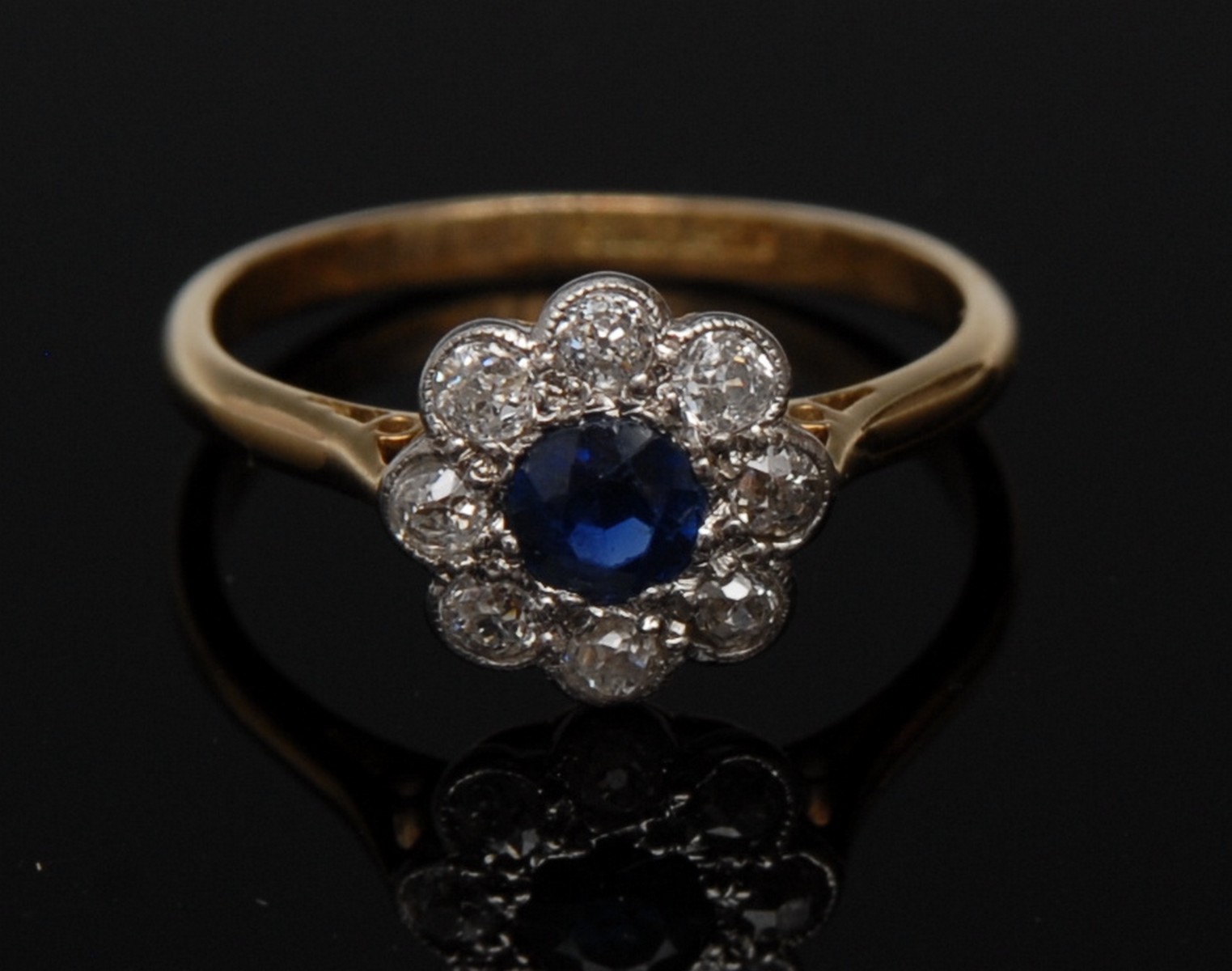 A sapphire and diamond flower cluster ring, central blue sapphire,