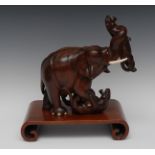 A Japanese hardwood carving, of an elephant battling with tiger's, ivory tusks and features,