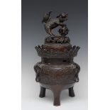 A Japanese dark patinated bronze tripod koro and cover, temple lion finial,