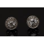 A pair of diamond earrings, each with a central round brilliant cut diamond,