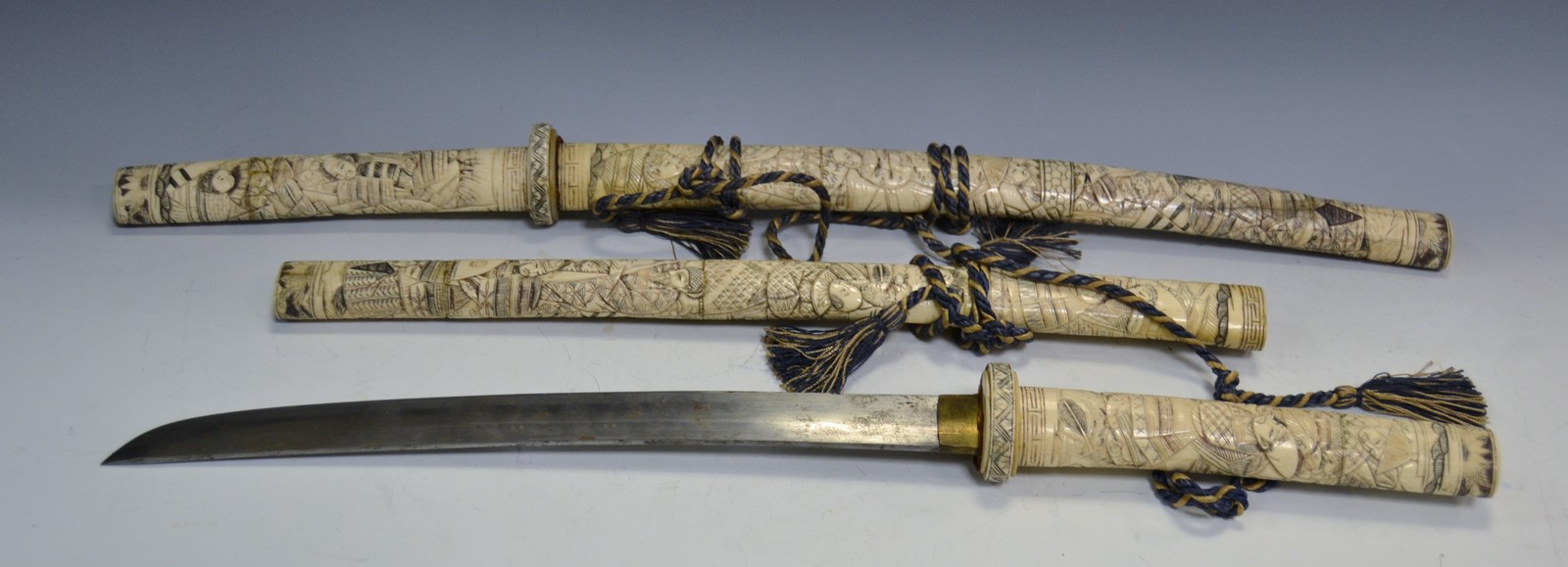 A Japanese carved Katana sword, of curved outline, carved overall with figures and foliage, 69.